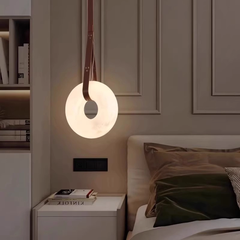 Bedroom alabaster circular pendant light: leather strap design, paired with a bedside and shelf, warm lighting ambiance